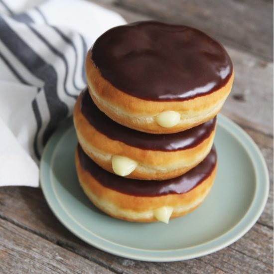 Stack of donuts with chocolate icing, showcasing the creativity of an icing manufacturer who also specializes in buttercreme icings.